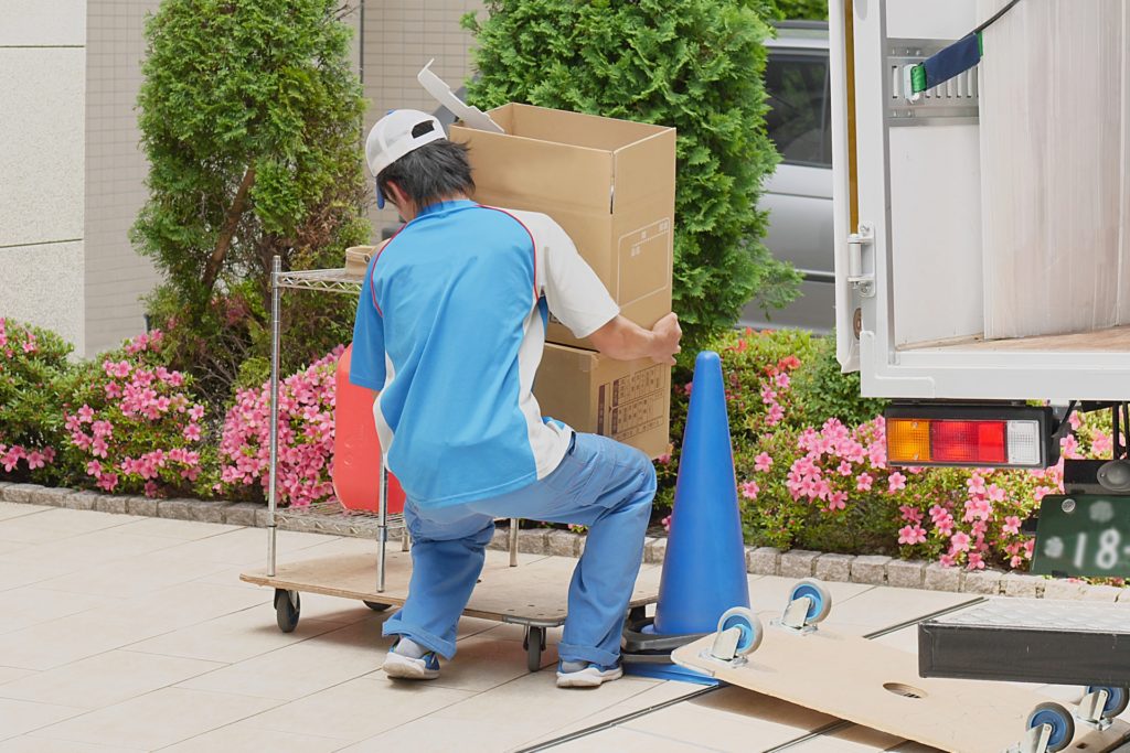 荷物を運ぶ仕事で腰を痛める男性